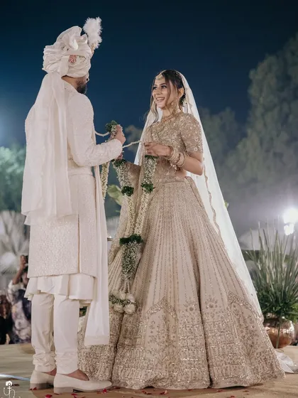 A candid moment during the varmala ceremony. The bride's makeup remains flawless and radiant, proving that a soft, natural look can be just as durable and impactful for the main event.