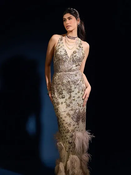 A full-length view of a modern, glamorous gown. The makeup is kept sophisticated and chic, with a focus on a flawless base and defined eyes to complement the intricate beadwork.