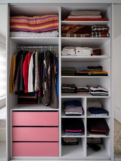 An example of a well-organized wardrobe interior. We design custom layouts with specific compartments for folded clothes, hanging items, and drawers for smaller accessories.