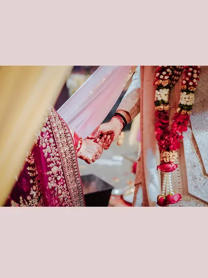A close-up shot of the couple holding hands during the ceremony, a simple yet powerful symbol of their union.