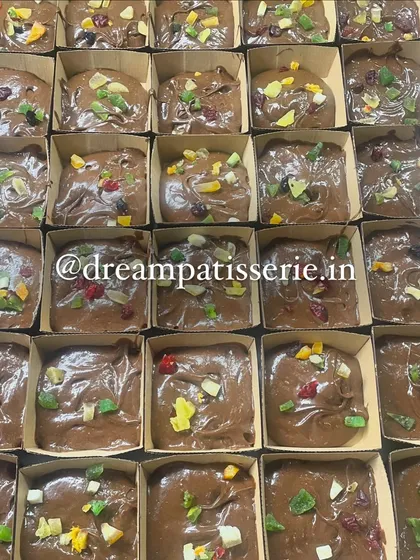 The brownie-making process for a bulk order. Here, the rich chocolate batter is topped with candied fruit before baking, ensuring every bite is full of flavor.