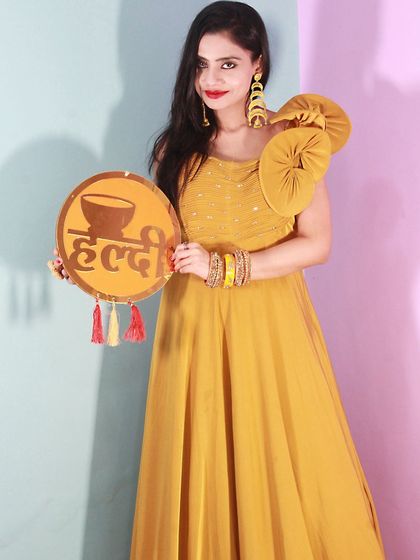 This mustard yellow gown with a unique shoulder detail is a perfect choice for a Haldi or Mehendi function. It's modern, stylish, and comfortable.