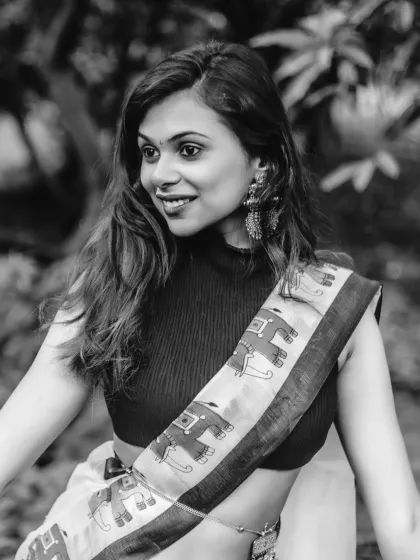 A beautiful black and white close-up, capturing the model's happy expression and the details of her modern saree and jewelry.