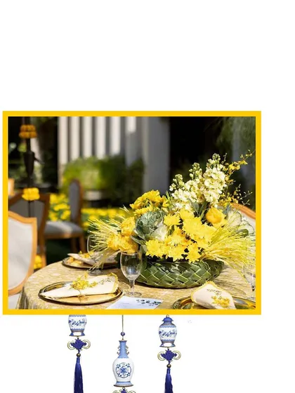 A close-up of the table centerpiece for our Blue Pottery theme, featuring yellow flowers that pop against the gold and blue table setting.