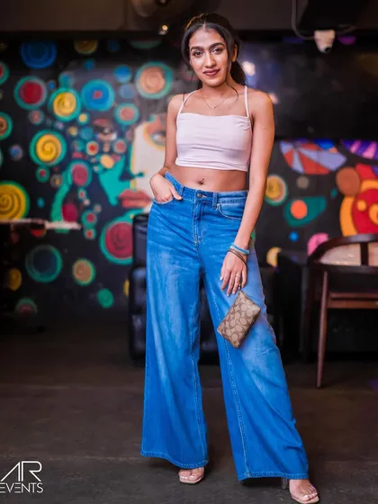 A guest in wide-leg jeans and a crop top, showcasing the trendy crowd.