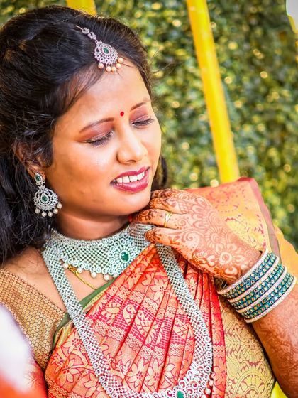 A candid portrait of the bride, glowing with happiness. The warm lighting and her gentle smile make this a beautiful, natural shot that captures her joy during the engagement ceremony.