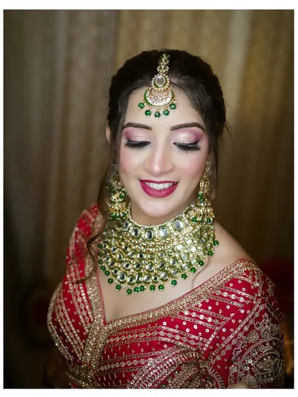 A serene portrait of the bride with her eyes closed, as if making a wish. This shot highlights her flawless makeup and the heavy, royal necklace.