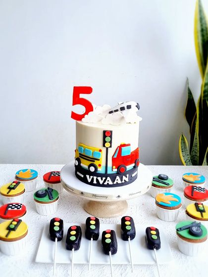 The full vehicle-themed dessert table, with the cake, cupcakes, and traffic light cakesicles.