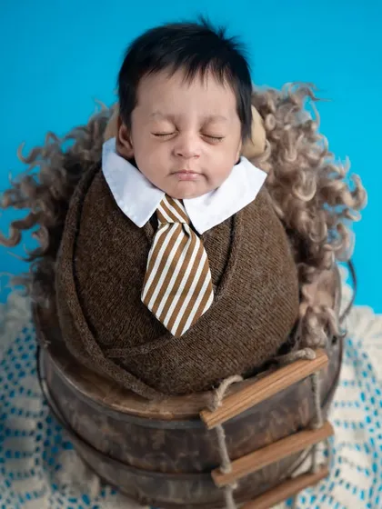 Dressed for success. This tiny gentleman in a wrap with a collar and tie is ready to take on the world, but first, a nap.