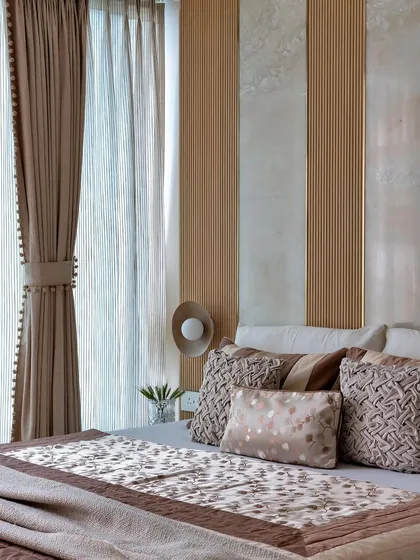 A detail shot showing how the light from the window softly illuminates the textures of the curtains and the layered bedding, creating a peaceful morning atmosphere.