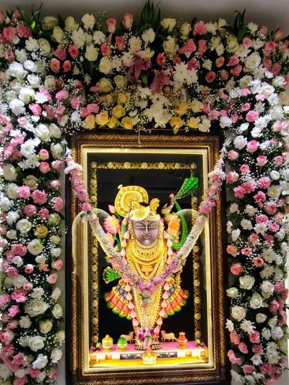 An elegant floral frame for a Krishna portrait, crafted with pink, yellow, and white roses. This decoration adds a divine and beautiful touch to any prayer room or special ceremony.