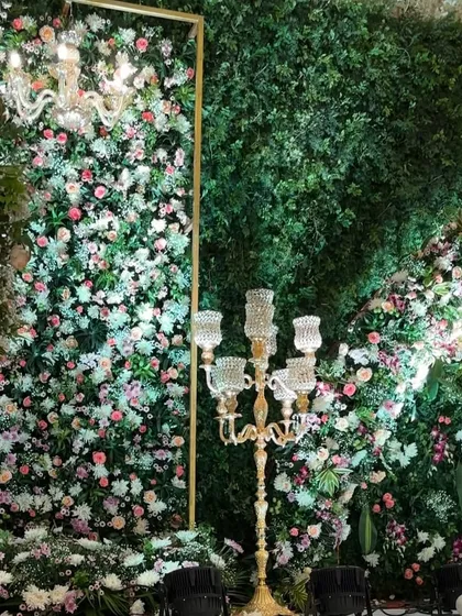 This image highlights the combination of a dense floral wall, a classic chandelier, and an ornate candelabra, showing how we layer elements for a rich look.