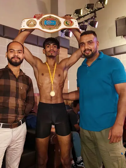 Holding the title belt high. This is the culmination of months of sacrifice and brutal training.