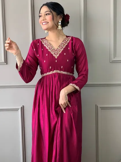 A rani pink kurta with an empire waistline. The heavy thread and sequin work on the yoke make it a flattering and festive choice.