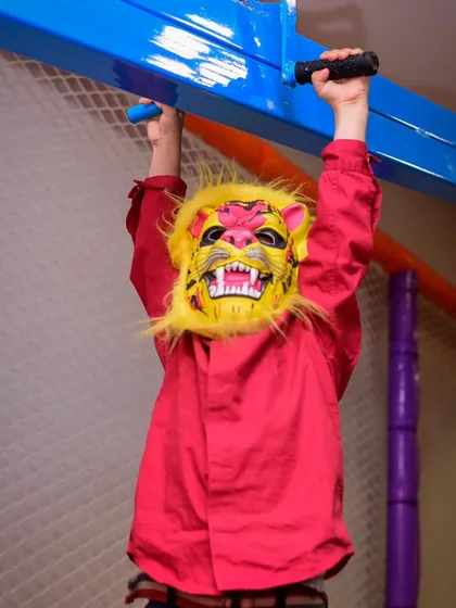 A little lion showing off his strength on the monkey bars in our play gym.
