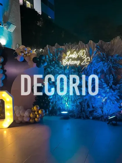 A full view of an outdoor 60th birthday party setup at night. The combination of marquee numbers, a custom neon sign, and dramatic lighting creates a truly memorable atmosphere.