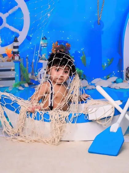 Caught in the net. This playful shot adds a touch of humor and creativity to the sailor-themed photoshoot, capturing a unique and adorable expression.
