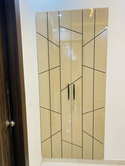 A two-door wardrobe with a high-gloss beige finish and a striking geometric pattern, perfect for smaller rooms.