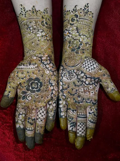 This design showcases a rich combination of techniques, including bold floral work, checkerboard fills, and delicate dot work, all typical of heavy Indo-Arabic mehendi.