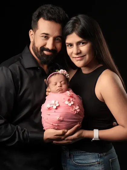 The first official family portrait. This classic shot against a dark backdrop is a timeless way to commemorate the arrival of your new baby and the beginning of your journey as a family of three.