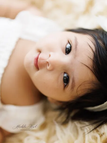 A slightly different angle, capturing the sweet and innocent expression of this baby. The neutral tones and soft textures are central to my timeless photography style.