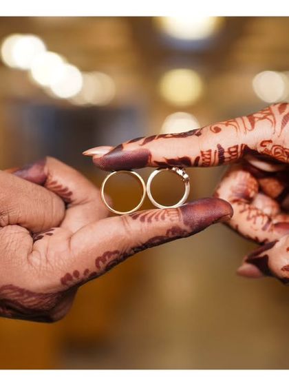 A creative shot of the engagement rings, held together to form a symbol of their union.