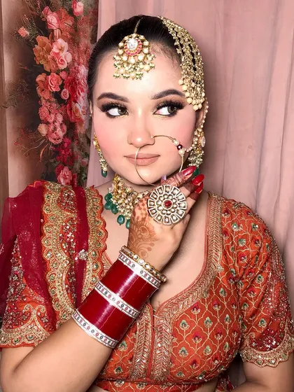 A close-up of the bride's hand, showing her statement ring that matches the rest of her kundan set.