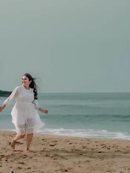 A joyful shot of a couple running along the water's edge. This captures the carefree and happy feeling of being in love.