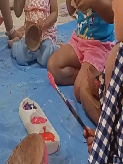A close-up of the painting activity, showing the colorful paints and the children's focused work.