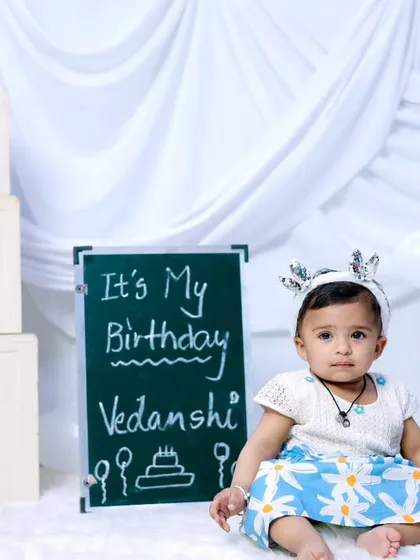 A personalized first birthday shoot with a chalkboard sign and classic 'ONE' blocks.