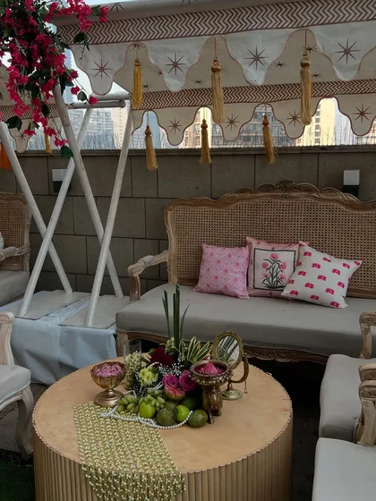 A cozy seating nook with a custom-printed canopy, elegant rattan furniture, and a detailed centerpiece.