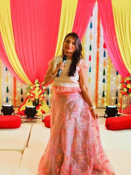 As an emcee, my job is to bring the party to life. Here I am, microphone in hand, hosting a lively Mehndi and Ganesh Pooja function. I ensure the event flows smoothly with engaging games and a vibrant atmosphere that gets everyone involved.