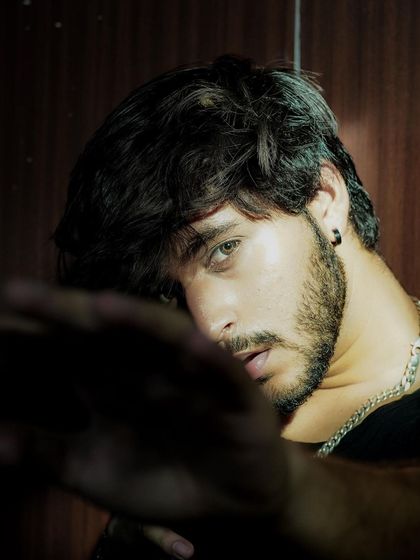 A moody and mysterious portrait with the model's face partially obscured. This artistic shot is perfect for an actor's headshot collection or a conceptual fashion story.