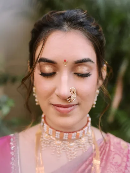 A close-up of Shalmali's classic bridal makeup. I focused on creating a neutral gold eyeshadow that beautifully complemented the zari of her Paithani saree and her skin tone. This is my signature minimal approach, ensuring every detail is balanced and graceful, especially in natural daylight.