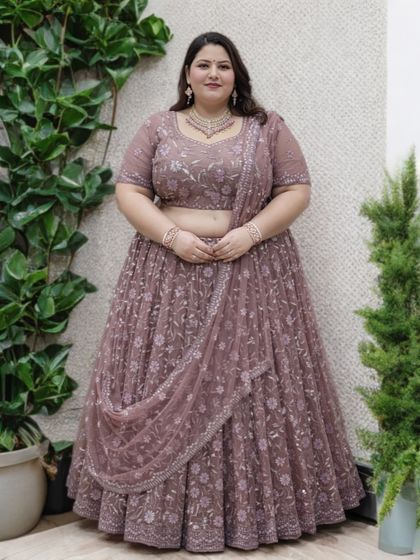 A lovely full-length shot of the dusty-mauve plus-size lehenga. The matching embroidered blouse and sheer dupatta create a cohesive and graceful silhouette.