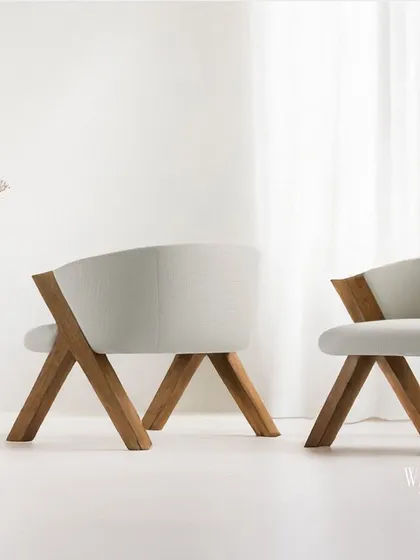 This natural wooden chair, with its clean lines and soft white upholstery, is a perfect blend of modern elegance and earthy charm. The unique cross-legged frame showcases our commitment to creating sculptural yet functional furniture.