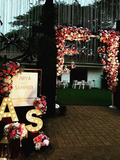 A personalized welcome entrance for a wedding reception. I created a lush floral arch and arranged flowers around the couple's initials in large marquee letters.