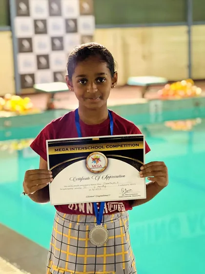 Celebrating the success of our young athletes. Here, one of our champions proudly displays her silver medal and certificate from a major interschool freestyle competition.