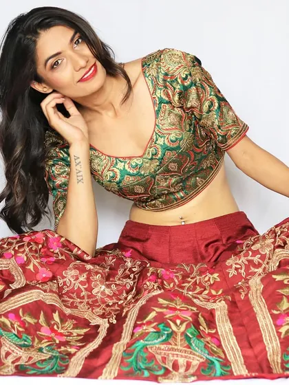 This outfit is a celebration of heritage, blending a traditional green Banarasi brocade blouse with a richly embroidered red raw silk skirt. It’s a smart ethnic lehenga that is perfect for a royal-themed wedding celebration.