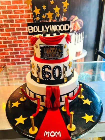 This three-tiered Bollywood-themed cake was designed for a spectacular 60th birthday party. Complete with a red carpet, film reels, and golden awards, it’s a showstopper for anyone who loves the glamour of cinema.