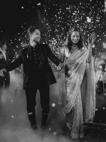 A grand entrance through a cloud of smoke. This black and white shot of Sanket and Sakshi has a magical, dreamlike quality, making their reception entrance truly unforgettable.