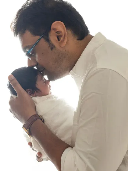 A father's gentle kiss. This close-up shot captures the tender bond between a dad and his newborn, highlighted by soft, natural-looking light.