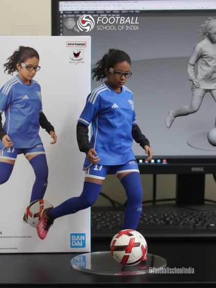 A young player with glasses, focused on the ball, is recreated as a detailed figurine.