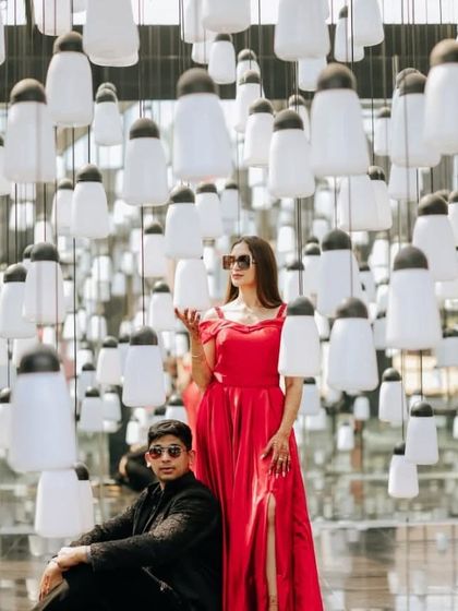A stylish couple's portrait featuring our red off-the-shoulder gown. The vibrant color and classic design make it a versatile choice for creative photoshoots.