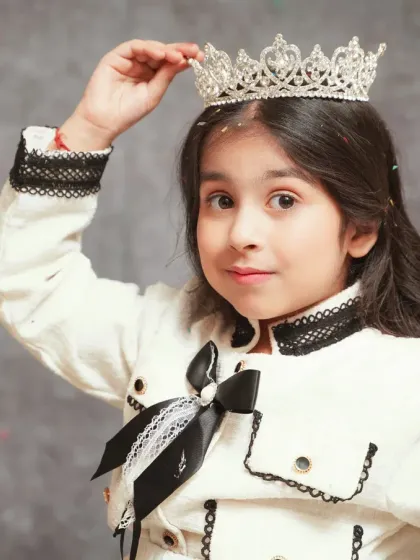 A close-up portrait of the birthday girl adjusting her crown. We capture these little personality-filled moments during our kids' birthday photoshoots.