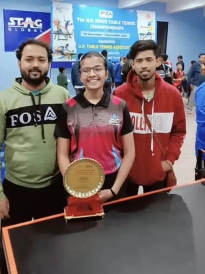 Samriddhi Sharma with her coaches, holding the Gold Medal plaque from the 71st UP State Table Tennis Championship.