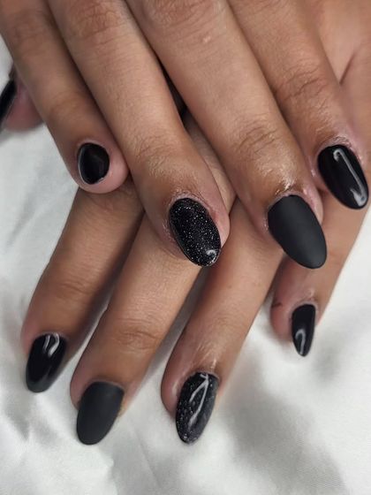 Shades of black. This set plays with texture, combining glossy black, matte black, and a sparkling black glitter nail for a chic and modern look.