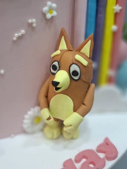 A close-up of the Bingo figurine from the Bluey-themed cake.