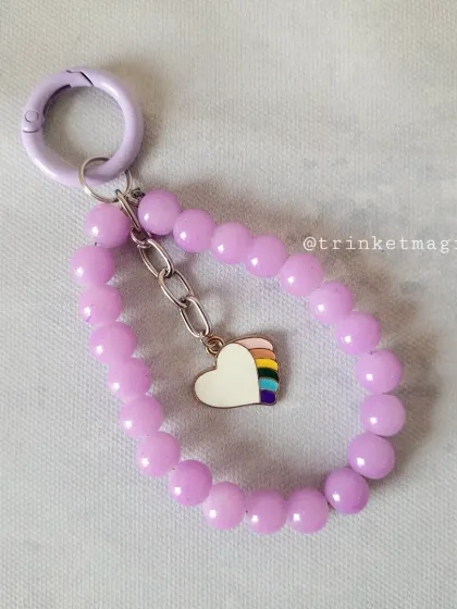 The same cute rainbow heart charm, this time on a pastel purple beaded loop. It's a simple, handmade piece that makes a sweet statement.