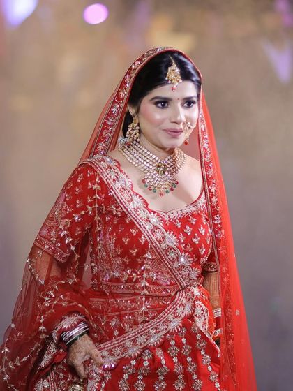 Walking in with grace and confidence. This look was all about classic elegance, featuring a timeless red lehenga and makeup that highlighted her best features with a warm, bridal glow.